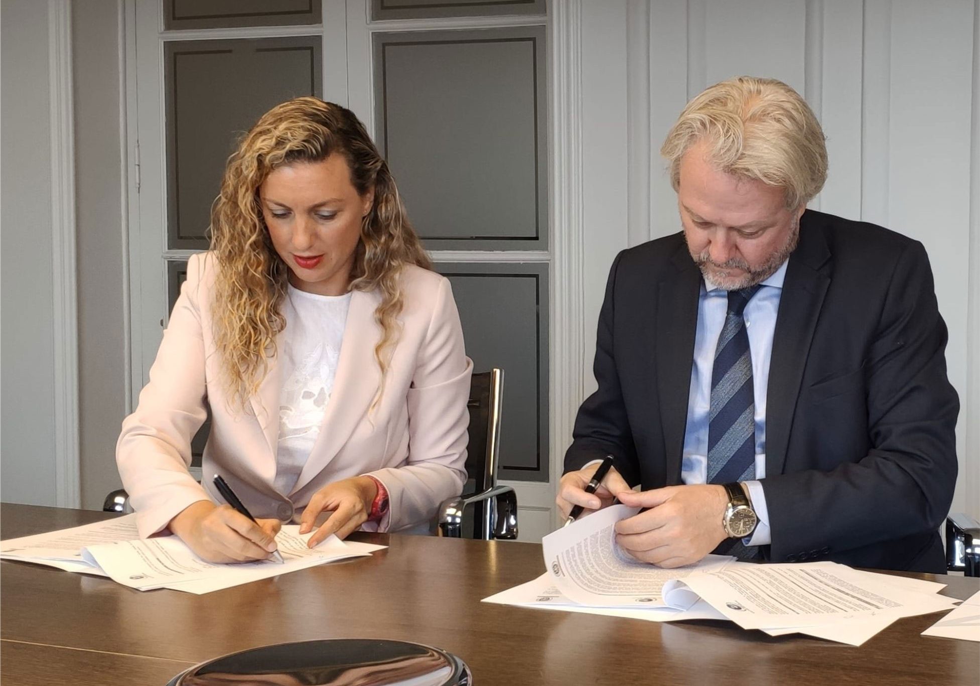 Ruth Ballesteros Gómez, Managing Director at Bureau Veritas Training Spain and Bruno Masier, President of the World Trade Point Federation, sign the agreement.
